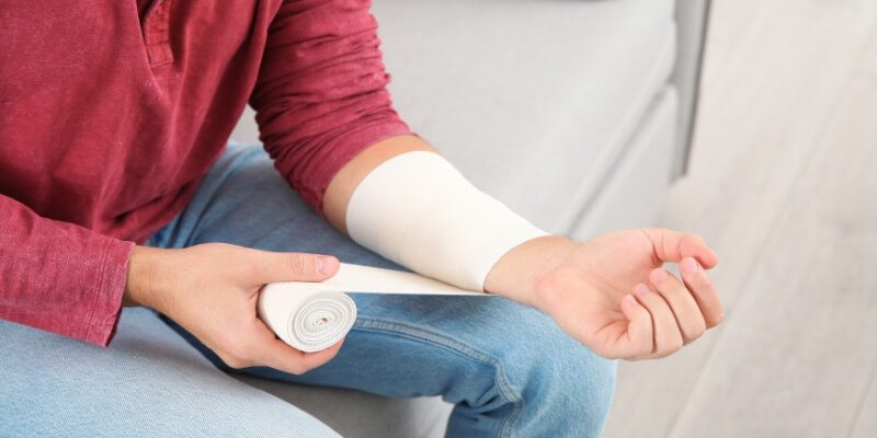 person wrapping wrist with bandage