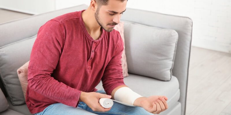 man in red wrapping wrist 